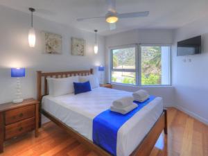 a bedroom with a large bed with two towels on it at Maggies Beachfront Apartment 10 in Horseshoe Bay