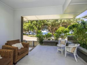 a patio with chairs and a couch and a table at Reflections Emerald Villa 1 in Picnic Bay