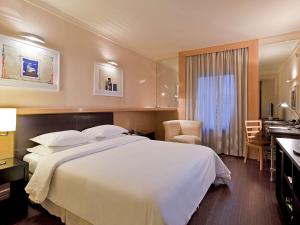 a hotel room with a large bed and a bathroom at Pullman Sao Paulo Ibirapuera in Sao Paulo