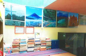 una pila de libros en una pared con carteles en Hotel Ideal, Your House in Quetzaltenango, en Quetzaltenango