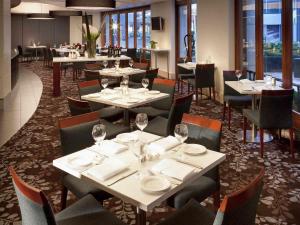 a restaurant with tables and chairs with wine glasses at Quay West Suites Melbourne in Melbourne