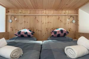 dwa łóżka w pokoju z drewnianymi ścianami w obiekcie Galerie Wohnung Hechelstein / Top 106 w mieście Tauplitz