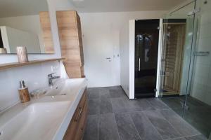 łazienka z białą umywalką i prysznicem w obiekcie Galerie Wohnung Hechelstein / Top 106 w mieście Tauplitz