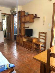 a kitchen with a desk with a tv and a chair at Apartamentos Cantarero Maro Nerja in Maro