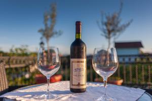 a bottle of wine and two wine glasses on a table at Apartman Mona in Podgorica
