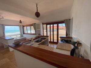 a kitchen with a counter top with a view of the ocean at Navegantes Nascente - Os Navegantes in Guajiru