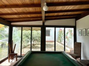 a pool table in a living room with windows at Casa Bianca Villa pool with sea view, fenced garden, barbecue by ToscanaTour in Castellina Marittima