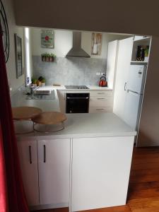 a kitchen with white cabinets and a stove top oven at Old world charm in town and by the sea in Napier +4 photos