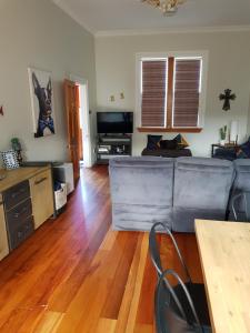 a living room with a couch and a wooden floor at Old world charm in town and by the sea in Napier