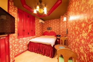 a small bedroom with a bed and a table and chairs at リトル チャペル ココナッツ 天王寺 in Osaka