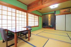 a room with a table and chairs in a room at kangetsusou in Unzen