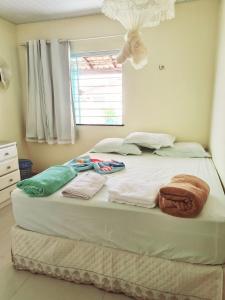 Una cama con toallas en un dormitorio en Casa Salinópolis Atalaia, en Salinópolis