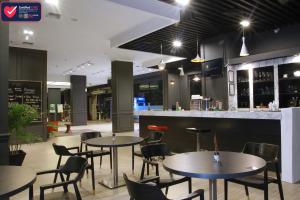 un restaurante con mesas y sillas y un bar en Sentral Cawang Hotel en Yakarta