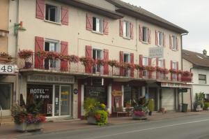 budynek z kwiatami na balkonach na ulicy w obiekcie Hôtel de La Poste w mieście Douvaine