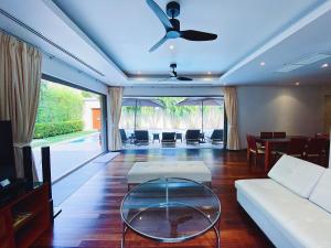 uma sala de estar com um sofá e uma mesa em Luxury 3br Pool Villa Walk To Bangtao Beach em Praia de Bang Tao