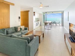 a living room with two couches and a dining room with a view at 1 Bright Point Apartment 4502 in Nelly Bay