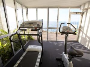 a gym with a treadmill and a view of the ocean at 1 Bright Point Apartment 5201 in Nelly Bay