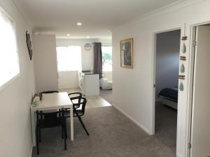 a room with a table and chairs and a bedroom at 2BD Family or Couple Guesthouse Upstairs near Turf club, HOTA in Bundall in Gold Coast