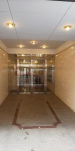 un vestíbulo vacío con puertas de cristal en un edificio en ホテルサンクリスター, en Tokio