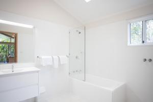 a white bathroom with a sink and a shower at Fingal Bay Holiday Park in Fingal Bay +56 photos
