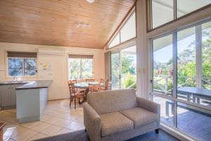 a living room with a couch and a table at Fingal Bay Holiday Park in Fingal Bay