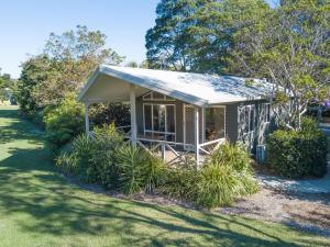 a small cottage with a porch in a yard at Fingal Bay Holiday Park in Fingal Bay