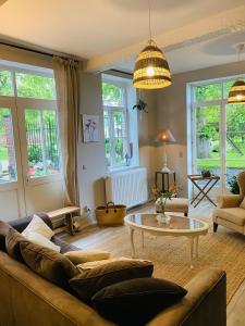 a living room with a couch and a table at Cosy house in a charming village in Beauvechain