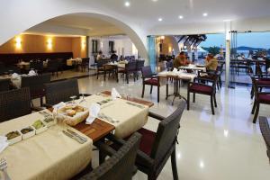 a restaurant with tables and chairs and people sitting at tables at Costa Bitezhan Hotel - All Inclusive in Bitez