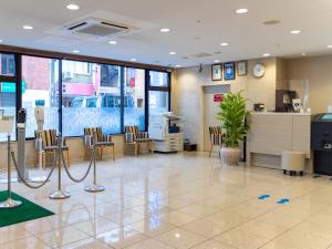 a lobby with a waiting room with chairs and a counter at Hotel Wing Port Nagasaki in Nagasaki