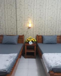 a room with two beds and a table with flowers at Villa Asri in Batu