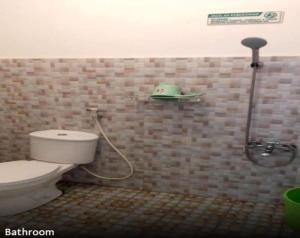 a bathroom with a toilet and a shower at Villa Asri in Batu