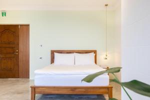 ein Schlafzimmer mit einem Bett und einer Topfpflanze in der Unterkunft 九份綠光 故事所 山中夢遊 - OwlStay Jiufen Green Ray in Jiufen