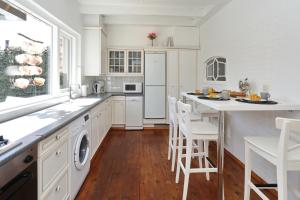 a kitchen with white cabinets and a table and chairs at Holiday home het Zeepaardje in Noordwijkerhout