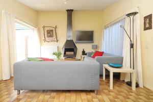 un soggiorno con divano e piano cottura di Holiday home Zeelust a Noordwijkerhout