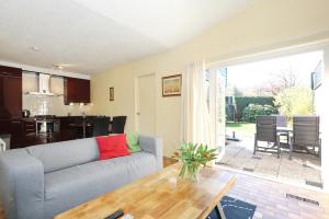 ein Wohnzimmer mit einem Sofa und einem Tisch in der Unterkunft Holiday home Zeelust in Noordwijkerhout