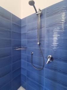 a bathroom with a shower with blue tiles at Astra in Agerola +37 photos