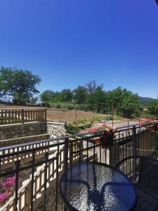 a table on a balcony with a fence and flowers at Astra in Agerola