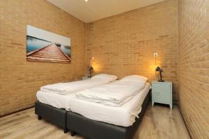two beds in a room with a brick wall at contract stopgezet 30-3-2024 in Noordwijkerhout