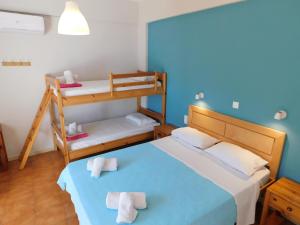 a bedroom with two bunk beds and a blue wall at Perdika Mare Guesthouse in Perdika