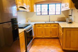 uma cozinha com armários de madeira e um frigorífico preto em Lugar de paz y serenidad em Dolores Hidalgo