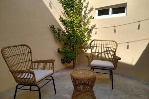 drie rotan stoelen en een tafel en een plant bij Lugar de paz y serenidad in Dolores Hidalgo