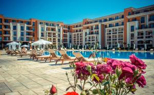 a resort with a swimming pool with chairs and flowers at Sea View Apartment PRESTIGE FORT BEACH , PREMIER FORT BEACH in Sveti Vlas