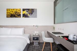 una camera d'albergo con un letto e una scrivania con un computer di CityInn Hotel Plus- Fuxing North Road Branch a Taipei