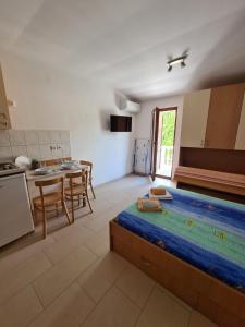 Zimmer mit einem Bett und einem Tisch sowie einer Küche in der Unterkunft Apartmani Jozic in Njivice