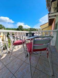 eine Terrasse mit 2 Stühlen und einem Tisch auf dem Balkon in der Unterkunft Apartmani Jozic in Njivice