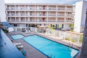 a large hotel with a swimming pool in front of a building at Waterfront North Beach Condo with beach and pool access in Corpus Christi