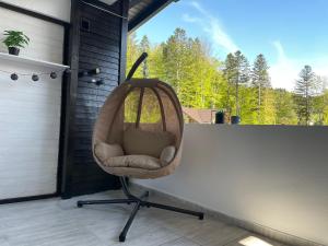 uma cadeira sentada num alpendre em frente a uma janela em Relax Apartment Predeal em Predeal