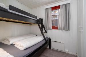 a bedroom with two bunk beds and a window at Knuts Hyttegrend in Beitostøl