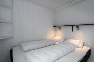 a white room with two pillows on a bed at Knuts Hyttegrend in Beitostøl