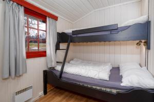 a bedroom with two bunk beds and a window at Knuts Hyttegrend in Beitostøl